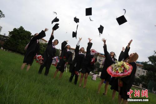 资料图：留学生抛帽子庆祝毕业。中新社发 赵琳露 摄